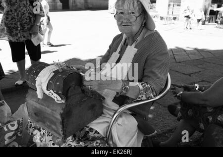 SALAMANCA, SPAIN, AUGUST 3: Unidentified elder woman demonstrating the intricate art of making pillow lace or bobbin lace, on Au Stock Photo