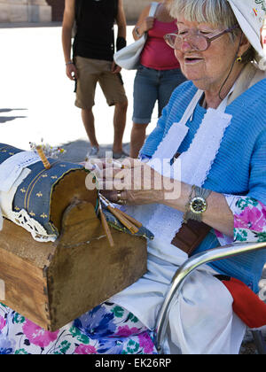 SALAMANCA, SPAIN, AUGUST 3: Unidentified elder woman demonstrating the intricate art of making pillow lace or bobbin lace, on Au Stock Photo