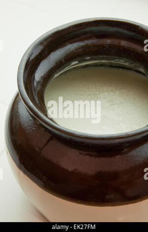 Crockery jar of sourdough starter used as the basis of making sourdough bread. Stock Photo