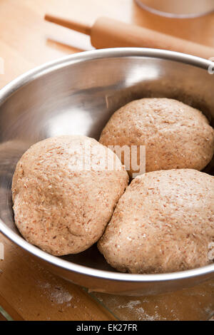 Three balls of multi-grain bread dough in large mixing bowl, prior to rising Stock Photo