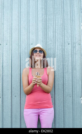 Joyful Girl with ice cream in hands looks at the top. Stock Photo
