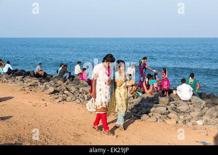 Local women in bright coloured saris walking on the beach in Pondicherry, or Puducherry, Tamil Nadu, southern India Stock Photo