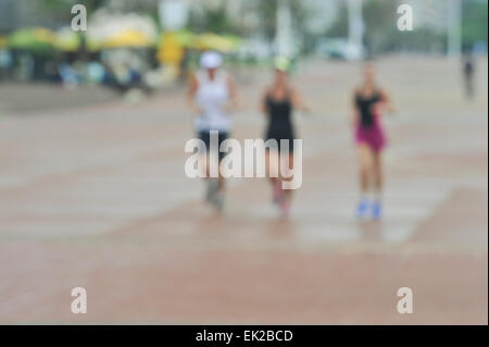 Focus blurred group of three women runners running along broad walk Stock Photo