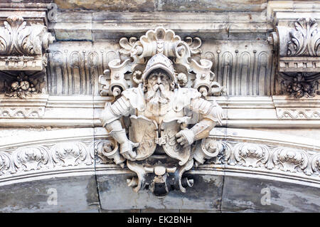 An elaborate stone carving of a historically dressed man at the top of an arch leading to a passageway towards the Schlossplatz Stock Photo