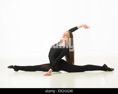 gorgeous ballet dancer performing a split on studio floor, on white background Stock Photo