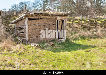 Part of viking age village replica in southern Sweden in early spring. Henhouse made of clay and juniper branches. Door closed, Stock Photo