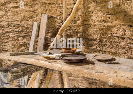 Part of viking age village replica in southern Sweden in early spring. Left behind wooden plates and a jaw bone of a pig on roug Stock Photo