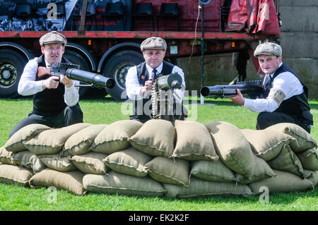 Larne, Northern Ireland. 26 Apr 2014 - Three men wearing period costumes hold a Vickers Light machine gun and two Lewis Automatic  machine guns as part of the commemoration of the 1912 UVF gun-running Stock Photo