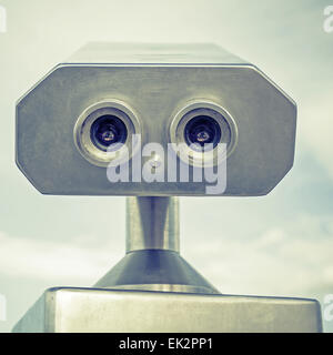 Paid outdoor tourist telescope made of stainless steel looks like a robot portrait. Vintage stylized photo with old style green Stock Photo