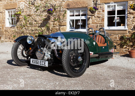 Edensor, Chatsworth Estate, Derbyshire, UK. 6th April 2015. A Morgan 3 Wheeler motorcar parked outside the tearooms in the Chatsworth village of Edensor, on a warm sunny spring morning in the Peak District. The new style Morgan 3-Wheeler went on sale in the U.K. in 2012 and is based on the original pre-war model which saw 30,000 models built between 1909-1953. Credit:  Mark Richardson/Alamy Live News Stock Photo