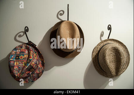 Three hats hang on three hooks inside a house Stock Photo