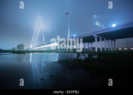 Wide long exposure shot of Margaret Hunt Hill Bridge in downtown Dallas Texas on a misty foggy night with a reflection. Stock Photo