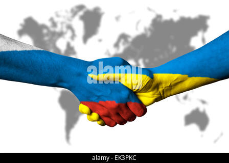 Russian flag and Ukraine flag across handshake in front of world map. Stock Photo