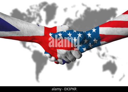 United Kingdom flag and USA flag across handshake in front of world map. Stock Photo