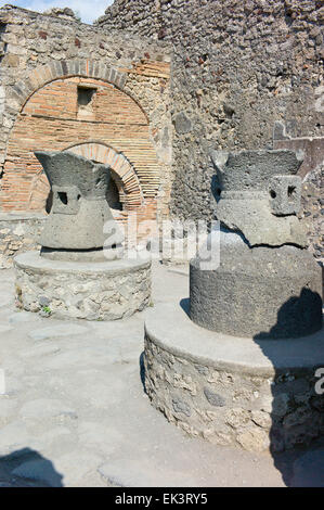 Mill stones at a bakery in the archaeological excavations of Roman Pompeii near Naples, Campania, Italy Stock Photo