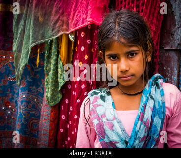 Young poor Indian beggar girl standing on the side of an indian street ...