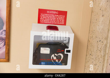 Portable automated external defibrillator (AED) mlunted on the wall in the public restroom at the airport Stock Photo