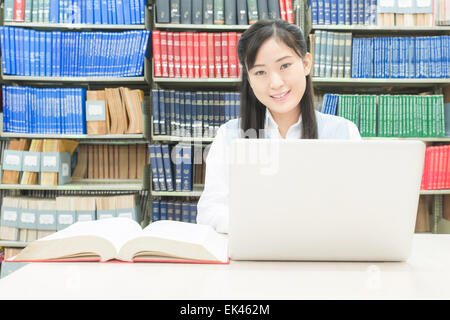 Asian student using laptop computer in college library Stock Photo