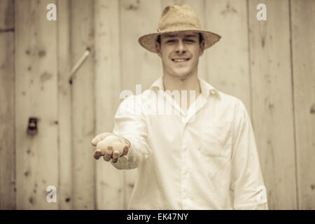 Closeup of Farmer Holding Eggs in front of a Farm Stock Photo