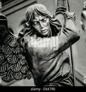 Close Up Detail Of Statue Of Archangel Michael With Outstretched Wings, Thrusting Spear Into Dragon Before Catholic Church Of St Stock Photo