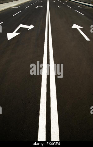 Road markings in the form of arrows on the asphalt road in the city Stock Photo