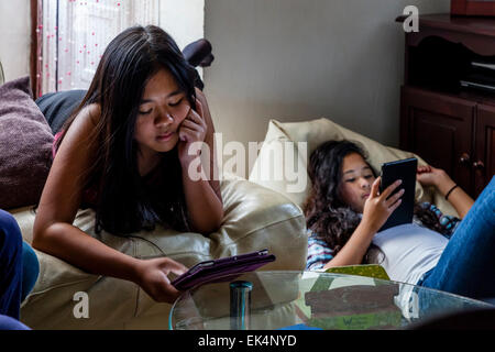 Two Girls Playing On Their Ipads/Tablets, Sussex, UK Stock Photo