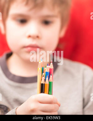 Caucasian child, boy, 3-4 year old, sitting on settee, holding in hand a  plastic cup and drinking from it while watching something in front Stock  Photo - Alamy