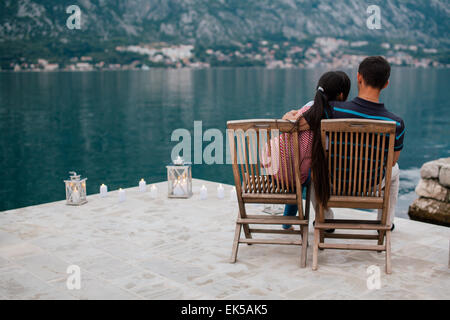 couple on the beach with candles in romantic place with mountain and bay view in Montenegro Stock Photo