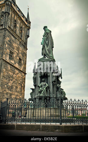 View at dusk of Emperor Charles IV monument and a tower of Charles bridge in Prague old town. Stock Photo