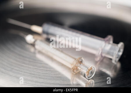 Two different syringes glass and plastic with types of hypodermic needles on sterile stainless steel polished medical tray Stock Photo