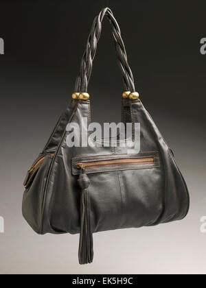 Studio photograph of a black leather handbag with a braided shoulder strap, tassel detail, and front zip pocket, isolated against a neutral gradient15. Stock Photo
