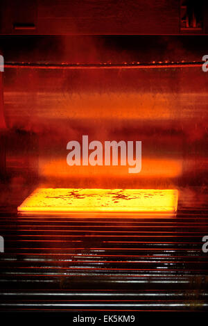 hot steel on conveyor inside of plant Stock Photo