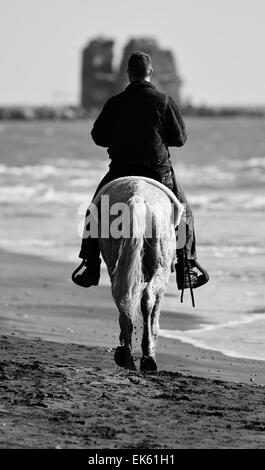 Italy, Lazio, Tyrrhenian sea, wwf Torre Flavia beach National Park (Rome Province), horse rider on the beach Stock Photo