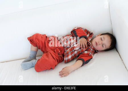 Two year old boy fast asleep on a couch Stock Photo