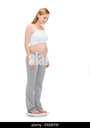 happy pregnant woman weighting herself Stock Photo