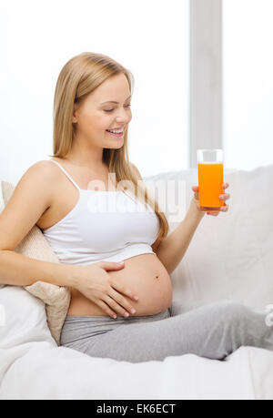 happy pregnant woman with fresh orange juice Stock Photo