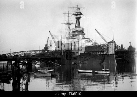 AJAXNETPHOTO. 1920-1930S. PORTSMOUTH, ENGLAND. - BATTLESHIP REFIT - A ROYAL SOVEREIGN CLASS BATTLESHIP, POSSIBLY HMS ROYAL OAK (SUNK 10/1939) OR HMS REVENGE, IN THE HUGE FLOATING DOCK LOCATED NR FLATHOUSE QUAY. NOTE THE LINKSPAN CONNECTING THE DOCK TO FOUNTAIN LAKE JETTY. SISTER SHIP ROYAL SOVEREIGN WAS BUILT IN PORTSMOUTH.  PHOTO:AJAX VINTAGE PICTURE LIBRARY REF:()AVL Stock Photo