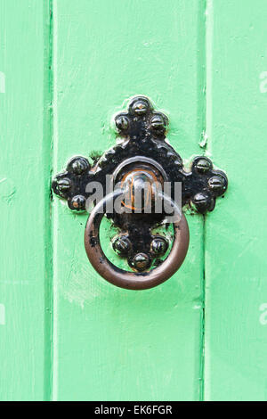 A black metal knocker on a green wooden door Stock Photo