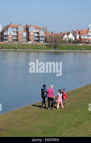 Family walking along the shore of Fairhaven Lake at Lytham on the Lancashire Coast Stock Photo