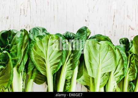Leaves and stalks of tatsoi on a wooden surface Stock Photo