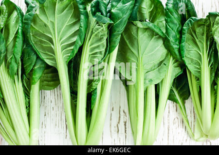 Leaves and stalks of tatsoi on a wooden surface Stock Photo