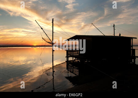 Fishing hut with a big net on a lagoon at sunset, Pialassa Baiona, Marina Romea di Ravenna, Italy Stock Photo