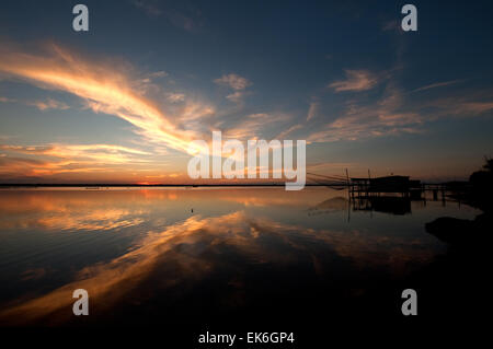 Fishing hut with a big net on a lagoon at sunset, Pialassa Baiona, Marina Romea di Ravenna, Italy Stock Photo