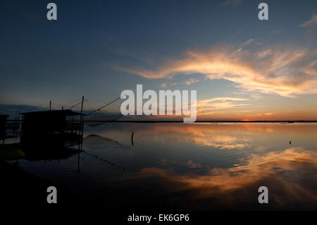 Fishing hut with a big net on a lagoon at sunset, Pialassa Baiona, Marina Romea di Ravenna, Italy Stock Photo