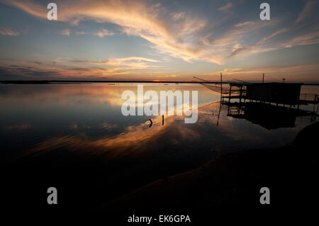 Fishing hut with a big net on a lagoon at sunset, Pialassa Baiona, Marina Romea di Ravenna, Italy Stock Photo