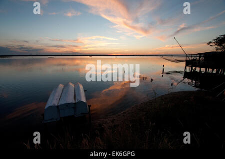 Fishing hut with a big net on a lagoon at sunset, Pialassa Baiona, Marina Romea di Ravenna, Italy Stock Photo