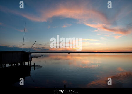 Fishing hut with a big net on a lagoon at sunset, Pialassa Baiona, Marina Romea di Ravenna, Italy Stock Photo