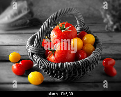Mixed fresh picked yellow and red plum tomatoes in a basket Stock Photo