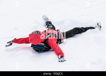 Backcountry skier making a snow angel near the Rifugio Fuciade, Pale di San Martino, Dolomite Mountains, Alps, Italy Stock Photo