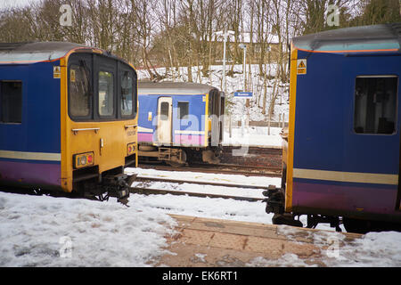 Buxton is a spa town in Derbyshire, England UK Northern Rail units wait in the snow at the train station terminus Stock Photo